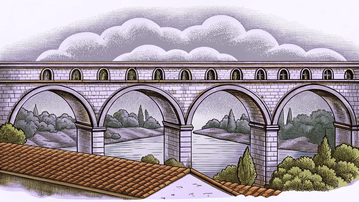 A stone arched bridge crossing a river beneath terracotta rooftops.