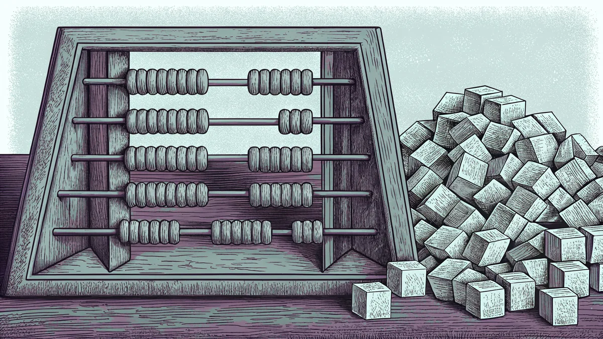 A wooden abacus strung with colored beads sits beside a heap of counting cubes on a table.