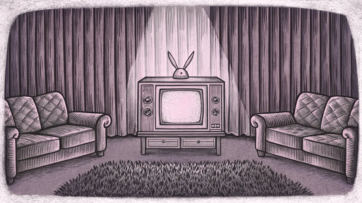 A vintage television with rabbit-ear antennae faces a mid-century sofa and side table on a patterned living room rug.