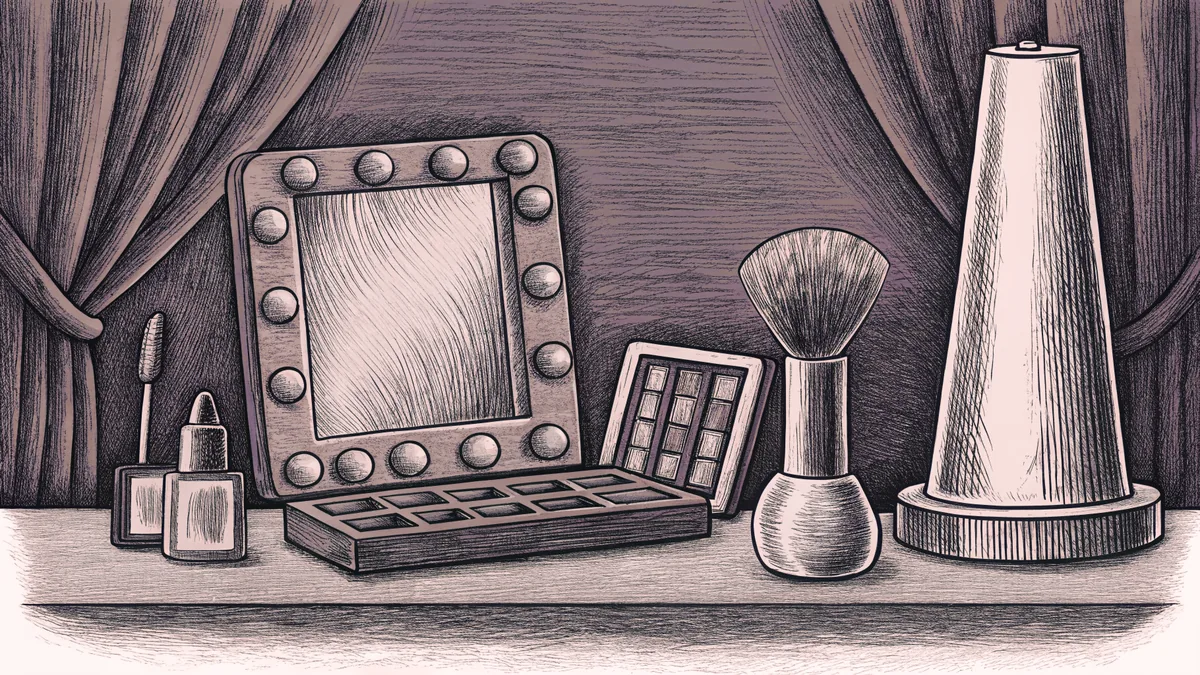 Makeup supplies and brushes arranged in front of a stage mirror with theatrical spot lighting.