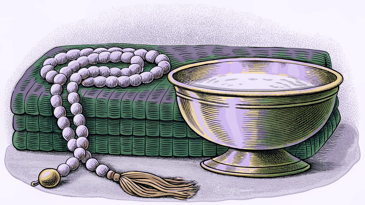 A beaded rosary coiled on folded cloth beside a footed brass bowl.