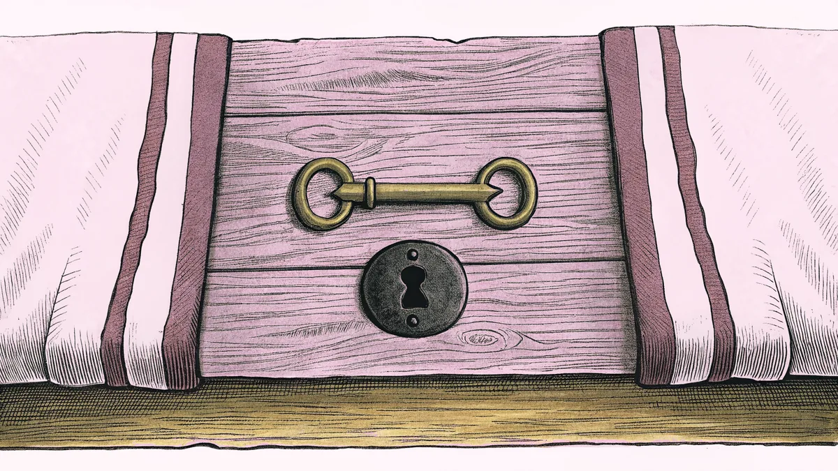 A small brass key lying beside an old keyhole plate on a worn wooden floorboard.