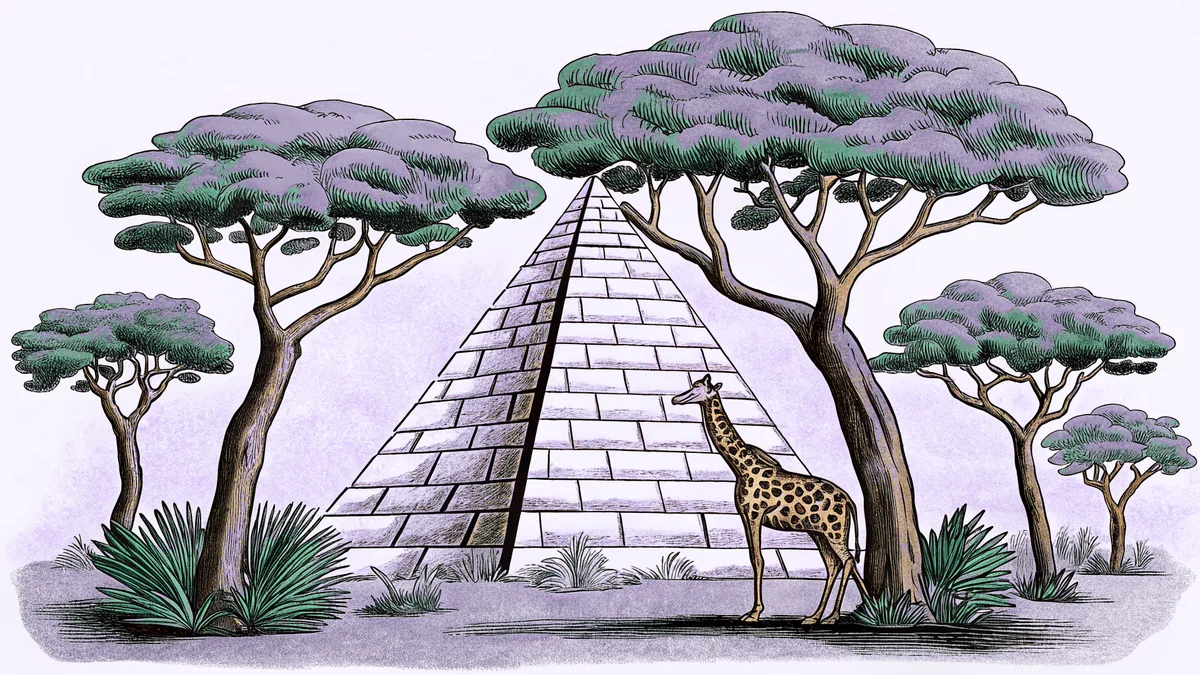A stone pyramid stands beside acacia trees where a giraffe crosses the savanna.