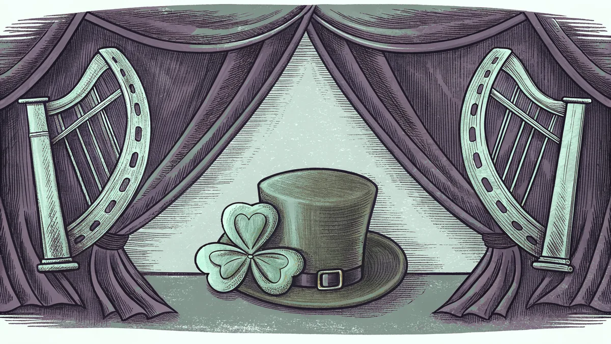 A shamrock sprig and green felt hat beside a brass harp and hanging bunting.