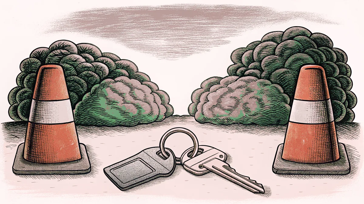 A set of car keys on a ring beside two traffic cones.
