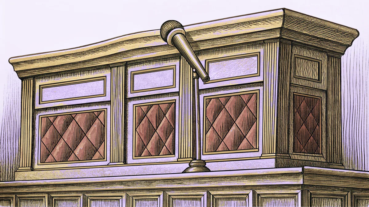 A polished wooden rail with a brass microphone mounted on it, on a carpeted riser.