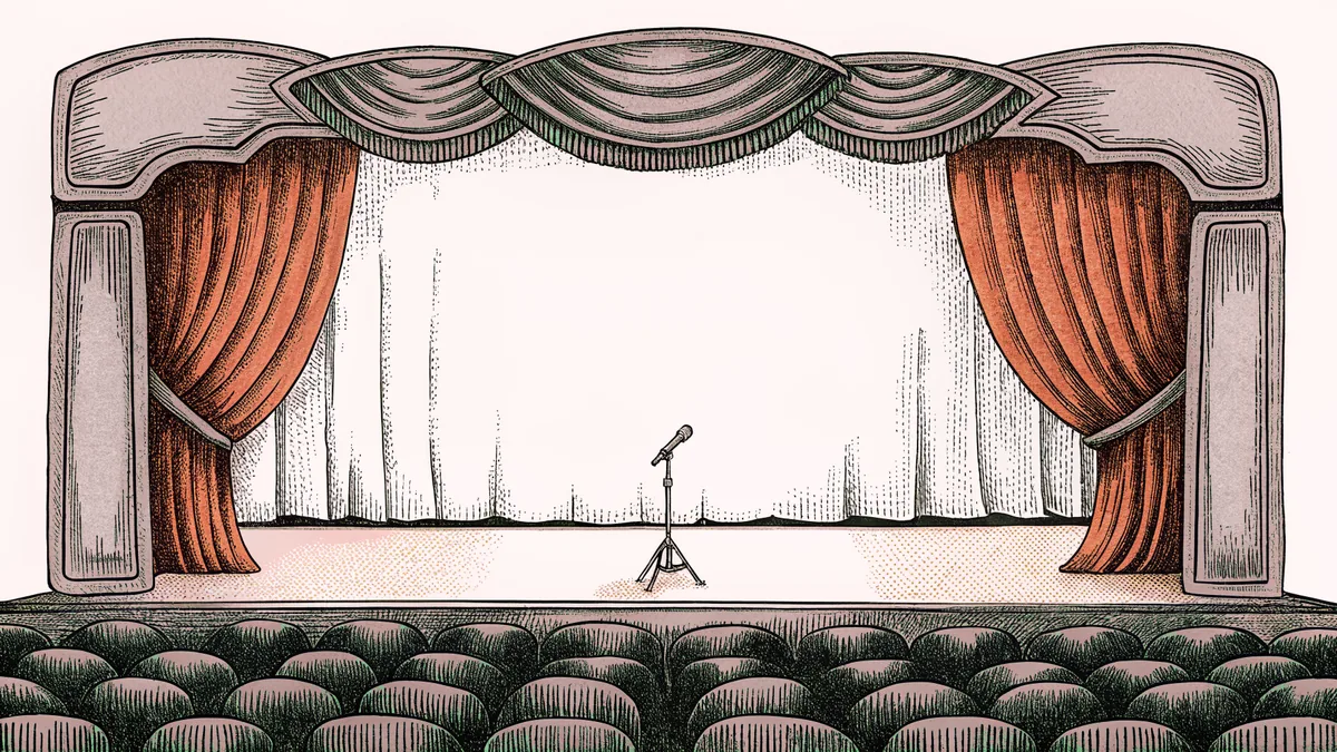 A blank clapper board and camera on a tripod rest on a dimly lit theatre stage.