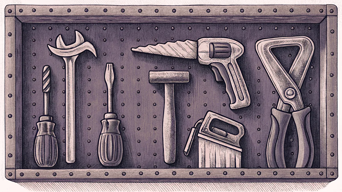 Workshop tools laid out on a bench including hammers, wrenches, screwdrivers, and saws.