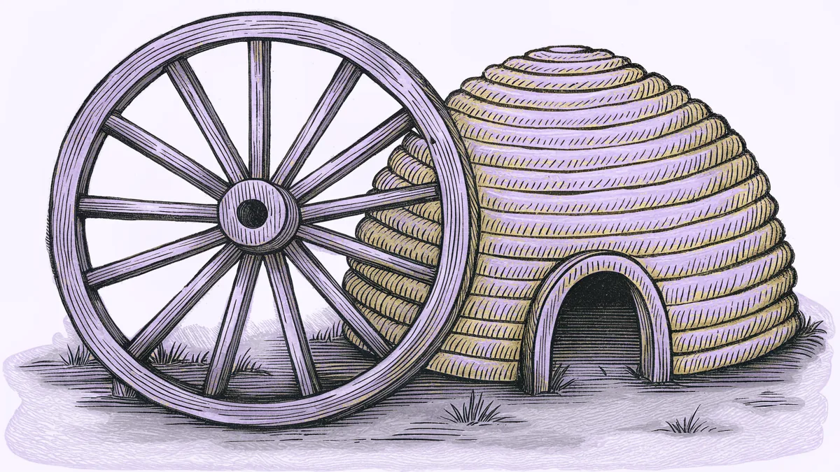 A wooden spoked handcart wheel leaning against a beehive-shaped thatched structure with an arched opening.