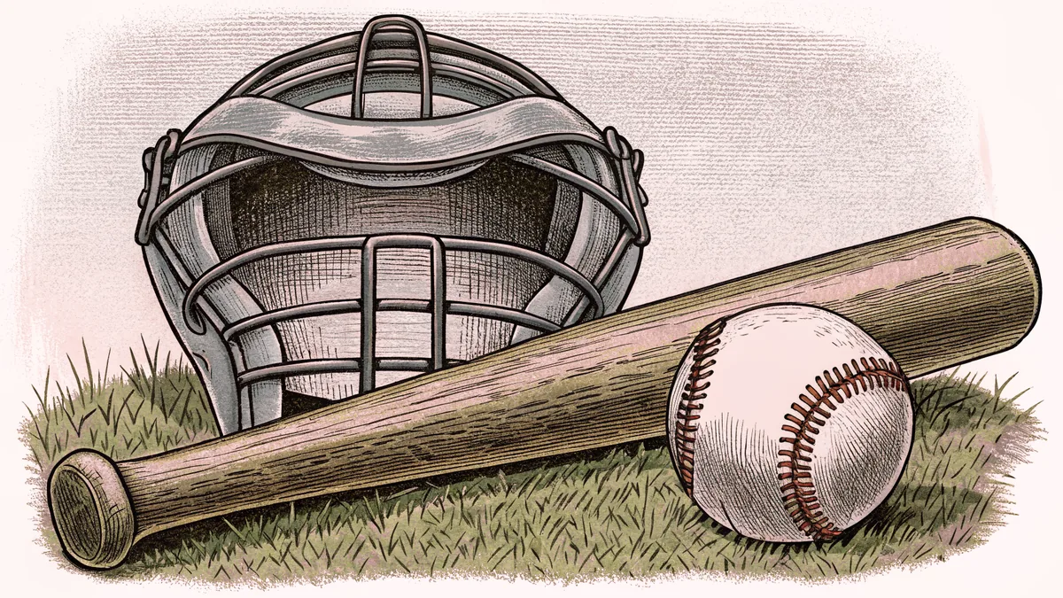 A wooden baseball bat lies beside a white baseball with a catcher's mask resting on green grass.