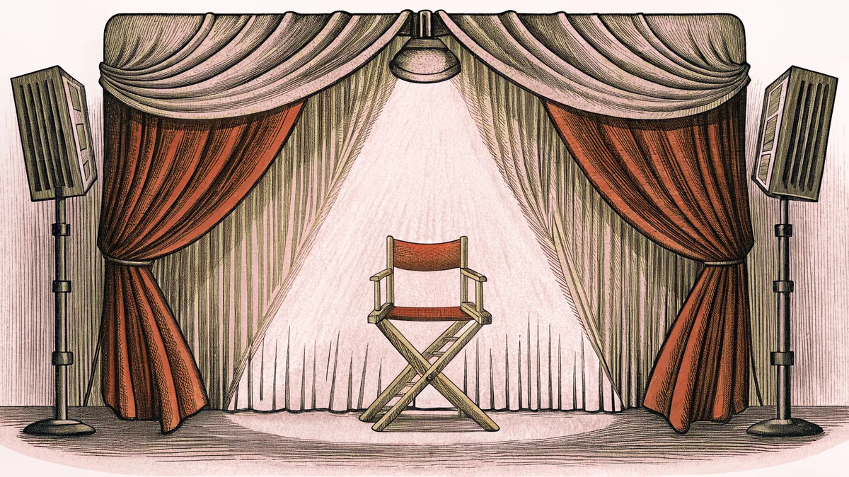 Two theatrical spotlights cross above a leather director's chair positioned center stage between rich velvet drapes.