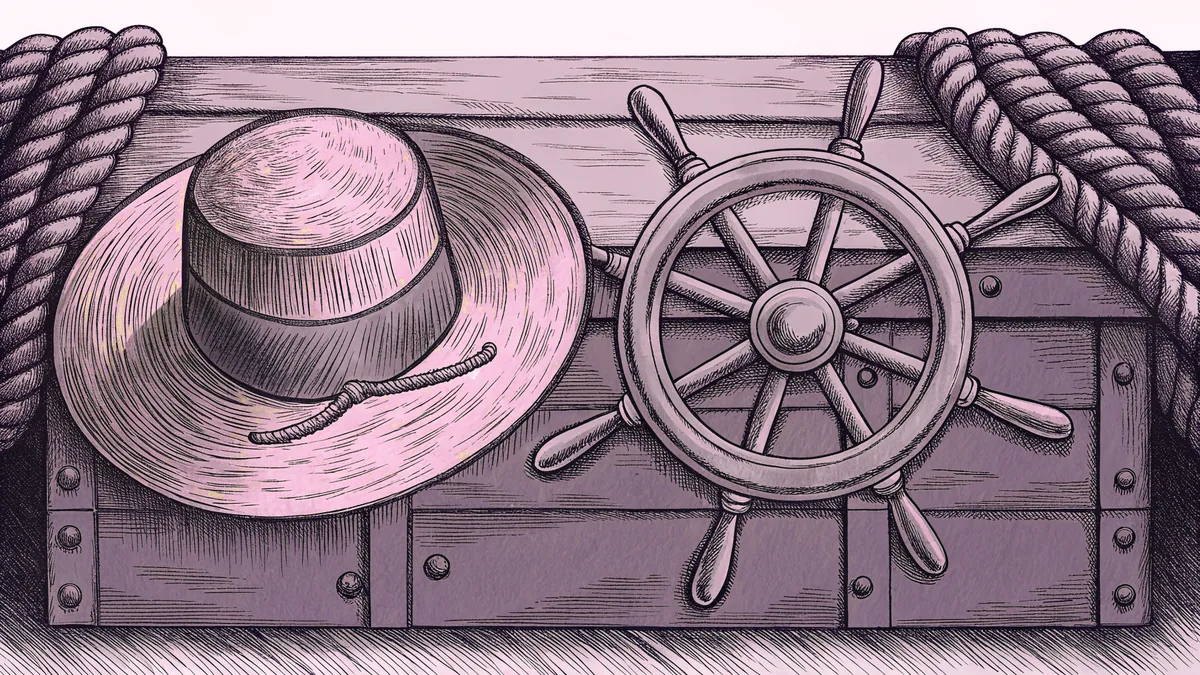 A straw hat rests on a ship's wheel beside a coiled rope and a wooden chest.