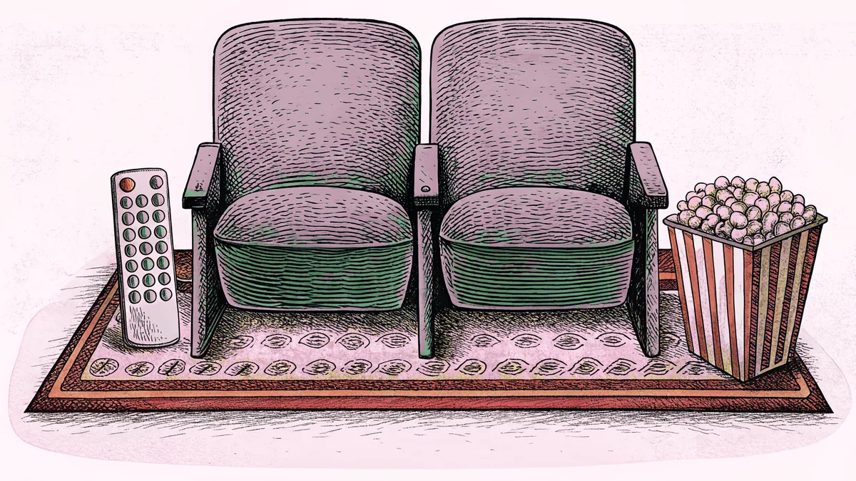 A remote control and popcorn box sit beside a cinema seat row on a rug.