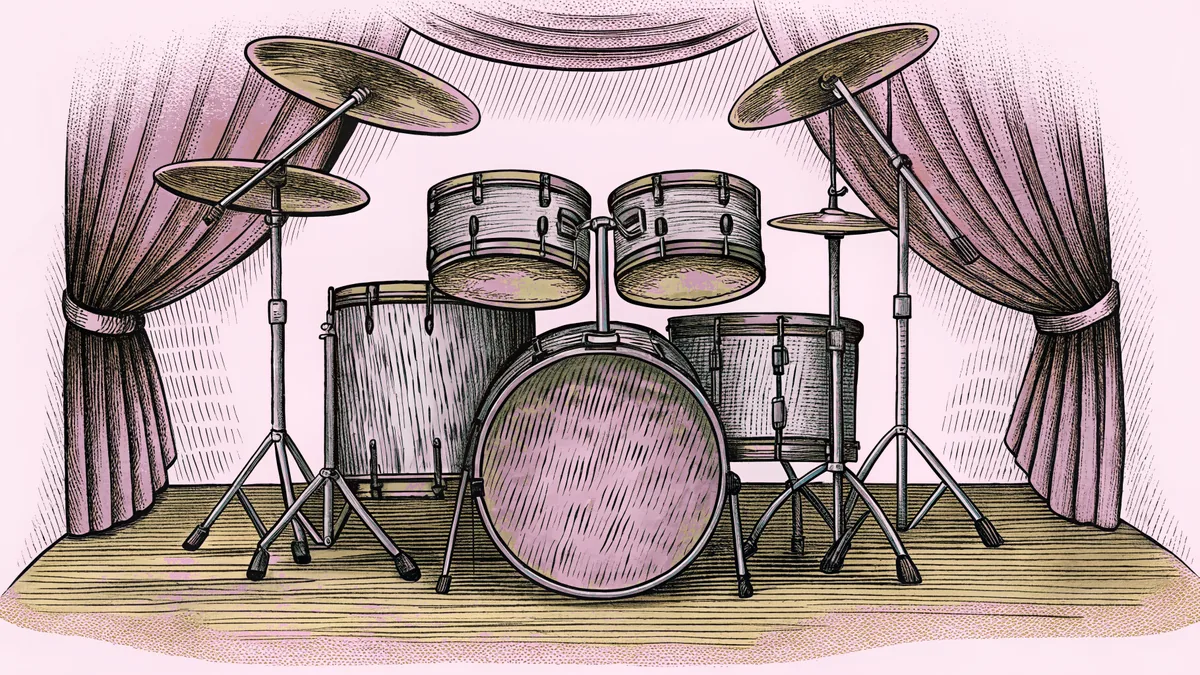 An assembled drum kit with crash cymbals and snare drum sits on a polished stage.