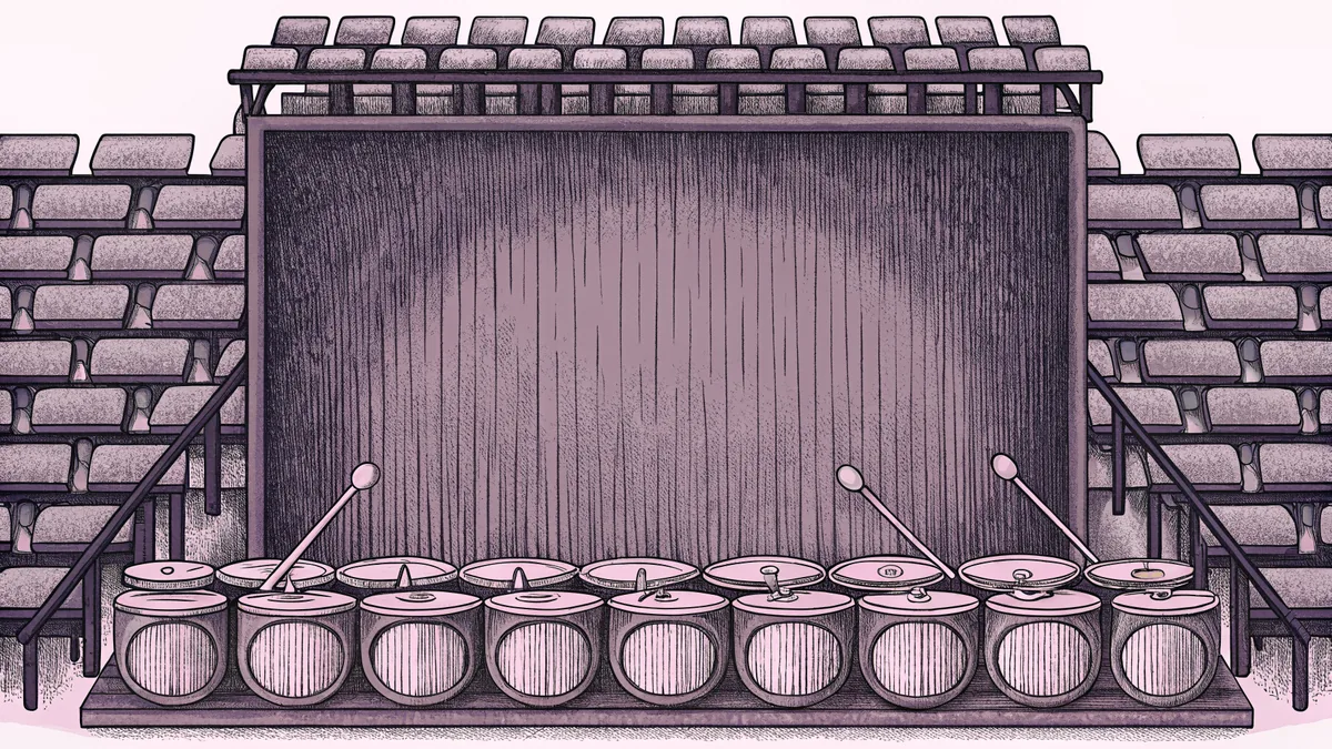 A percussion display shows drums, gongs, and xylophones on tiered stands with mallets, cymbals, and bells arranged around them.