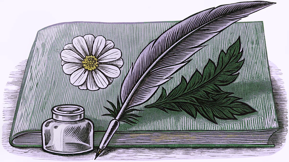 A quill pen stands in a glass inkwell beside a pressed flower on a worn wooden desk.