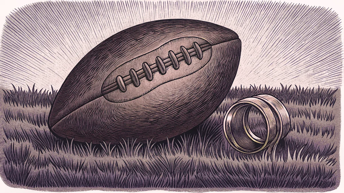 A football rests on emerald grass beside a gleaming championship ring under stadium lights.