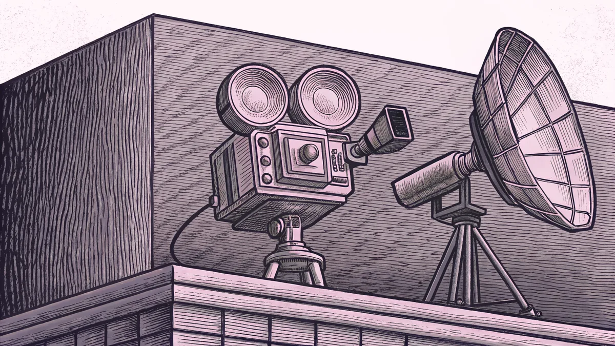 A studio camera and on-air lamp rest beside a satellite dish on a rooftop.