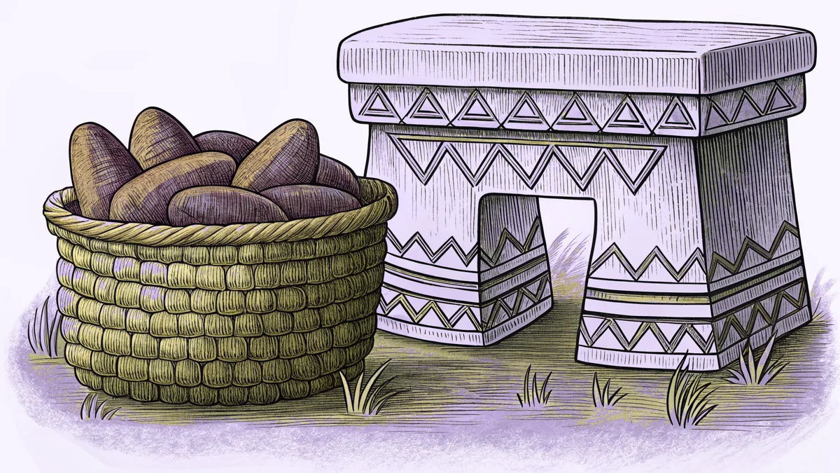 A basket of yams sits beside a carved ceremonial stool in a village clearing.
