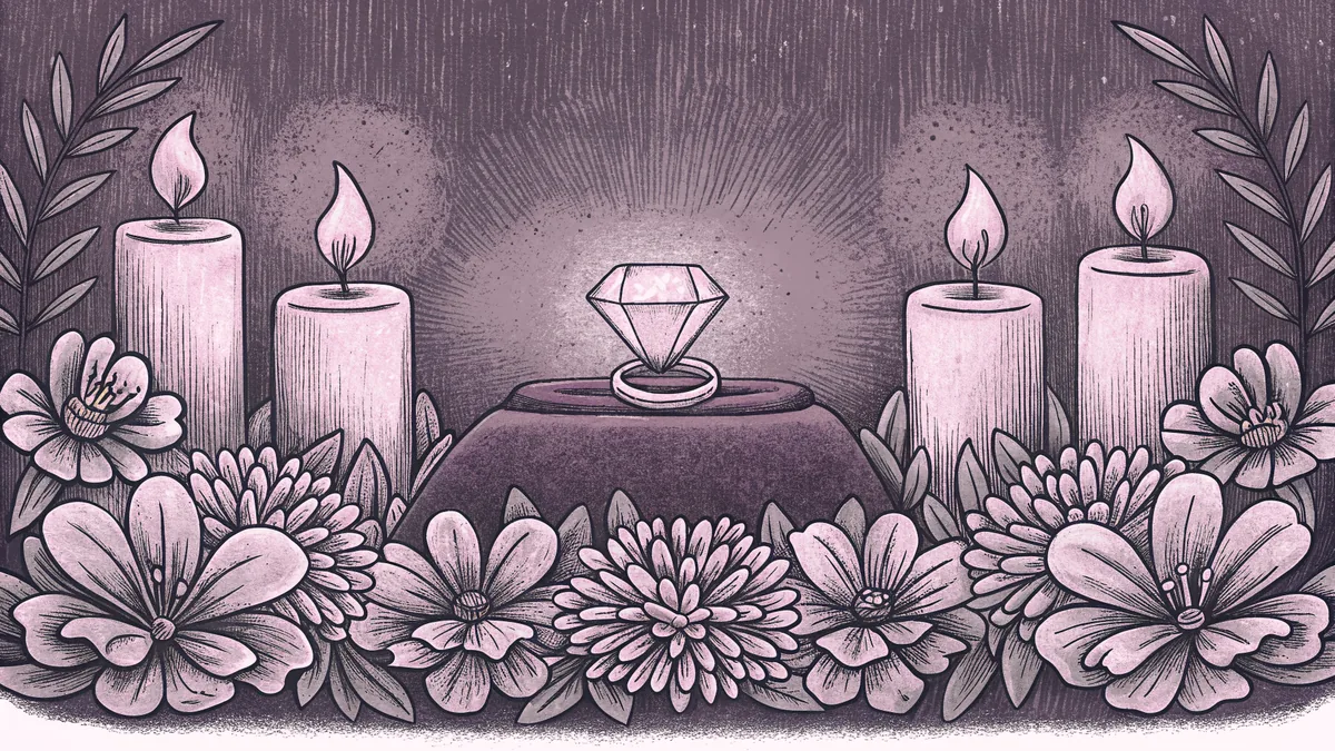 A diamond ring gleams among white flowers surrounded by heart-shaped candles.