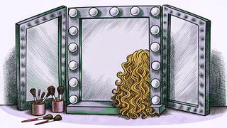 A styling station displays curly blonde hair beside mirrors under dramatic spotlights with makeup brushes and products.