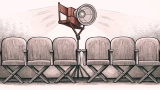 A director's chair stands beside a row of cinema seats under bright spotlights.