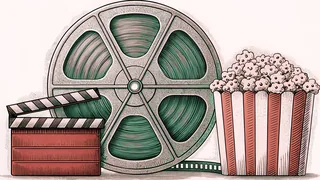 A film reel and blank clapper board rest on a counter beside a striped popcorn container.