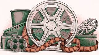 A gold film reel sits among ribbons and vintage camera gear on a dresser.