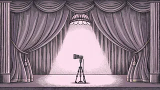 A studio camera and boom microphone stand near an on-air lamp on a soundstage.