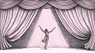 A dancer mid-leap on stage illuminated by a bright spotlight.