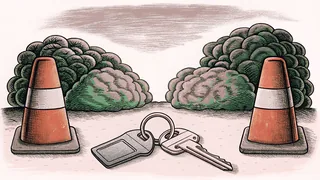 A set of car keys on a ring beside two traffic cones.