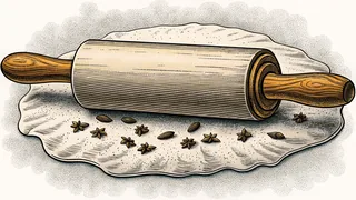 A wooden rolling pin lying on a floured board scattered with star anise and almonds.