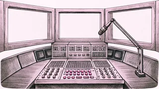 A professional microphone stand stands before a control console with lit indicator buttons in a recording studio booth.