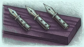 Three brass pen nibs arranged in a row on a slanted wooden board.
