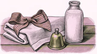 A red hair bow sits beside a small brass bell and a glass milk bottle on a pink cloth.