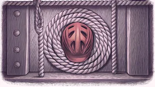 A thick coil of rope beside a red bicycle helmet on wooden planks.