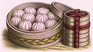An open bamboo steamer holding dumplings, stacked beside a second lidded steamer basket.