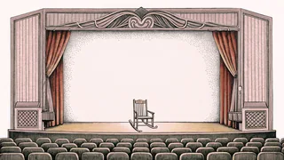 A theatre marquee with unmarked lettering sits near a rocking chair on a stage.