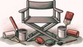 Paint pots and brushes are scattered across a director's chair on a studio floor.