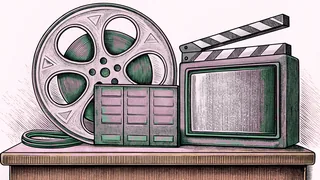 A film reel and boxy television set rest beside a clapper board on a counter.