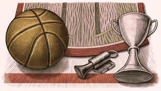 A leather basketball rests on a glossy court floor next to a golden championship trophy.