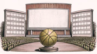 A golden basketball trophy stands beside an orange basketball on a polished wooden pedestal.