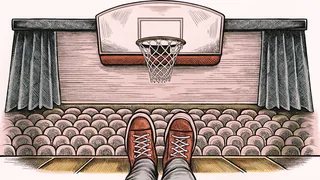 A basketball hoop and net hang above a polished court with white sneakers.