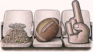 An American football rests on a stadium seat beside a foam finger and a bag of peanuts.