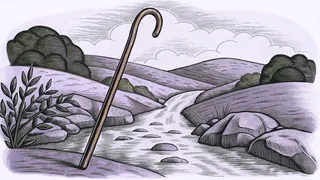 A shepherd's staff beside flowing water in lush green pastures with mountains beyond.