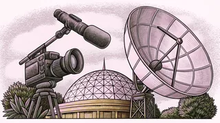 A studio camera and boom microphone rest beside a satellite dish in a studio.