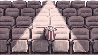 A vintage popcorn container sits beside a row of theatre seat silhouettes, lit by a dramatic spotlight.