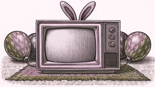 A boxy television set with rabbit-ear antennae sits beside balloons on a rug.