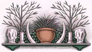 Dried savanna grass and acacia branches fill a terracotta pot beside carved animal bone totems.