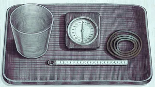 A measuring cup sits beside a ruler and bathroom scale with a thermometer displaying temperature readings.